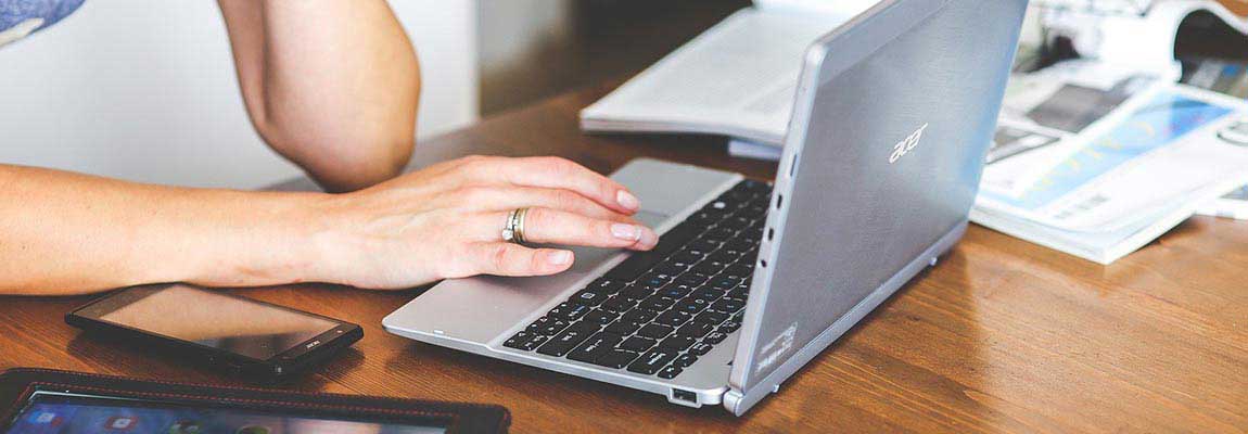 Decorative image of a person typing on a laptop